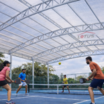 Pickleball players playing under Lotus Roofings polycarbonate roofing with diffused daylight, reduced heat and weather protection on a professional court.